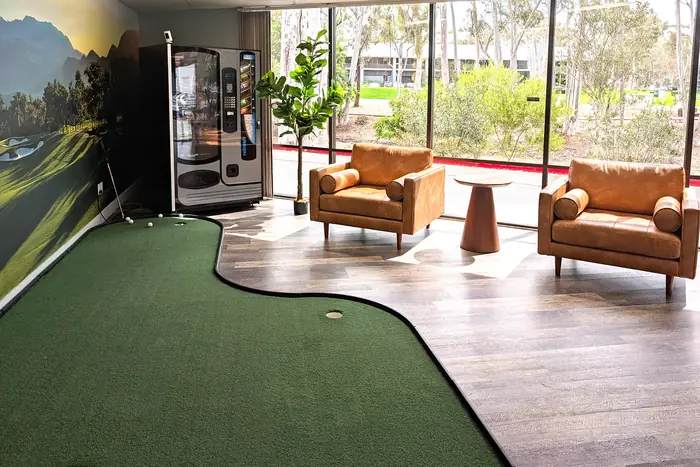 Pureshot's lounge with a practice putting green, armchairs and big windows
