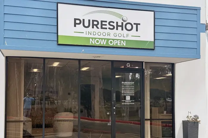 Pureshot Indoor Golf storefront with its green 'Now Open' sign at 10035 Carroll Canyon Rd, Ste G